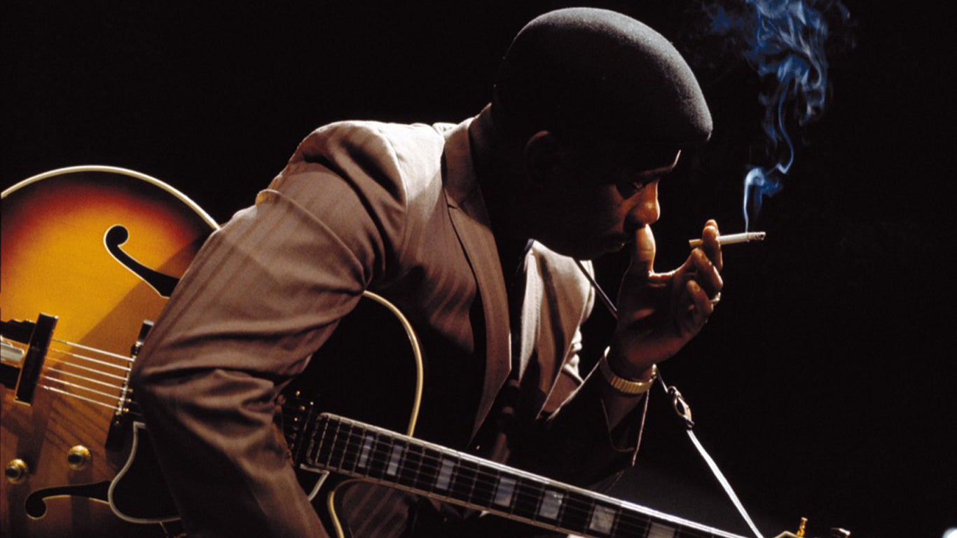 Man smoking with guitar in hand